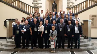 Image of university authorities, representativesm both from Poland and Uzbekistan standing on the main staircase in the AGH Univeristy hall