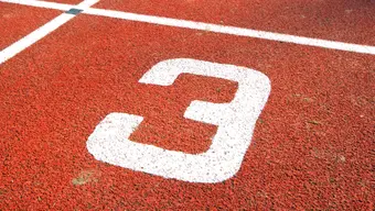 Image of an orange running track with number three