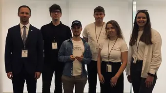 Image of 5 members of the Transpeed AGH research club with their supervisor, one of the students is holding an award