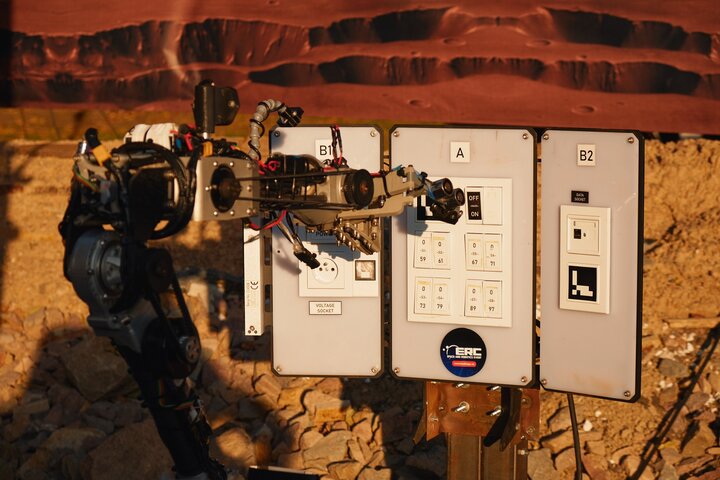 Image of a rover performing a task involving switches in a Martian-like space