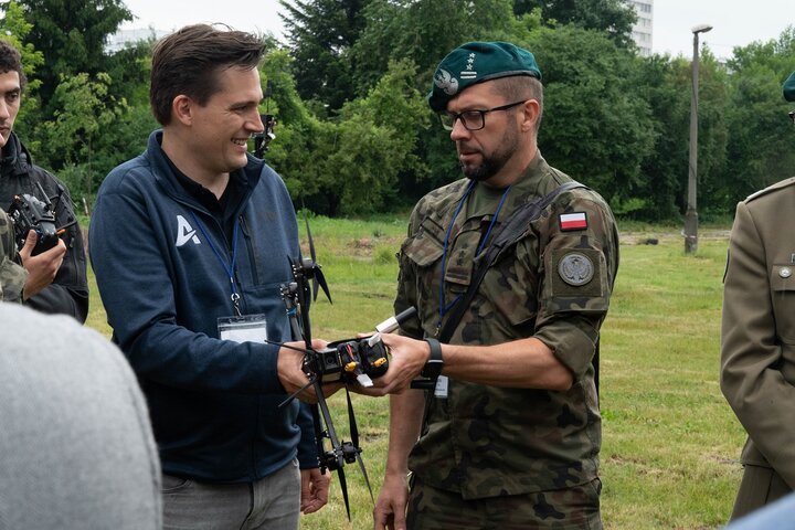 Image of two men, one being a general, holding a drone