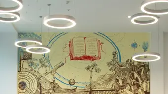 Interior of a modern library reading room with circular ceiling lights and a mural featuring books and scientific motifs.