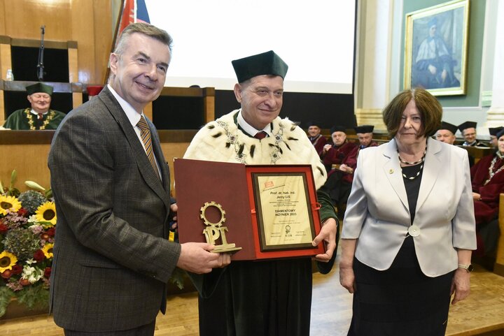 AGH University Rector receives a commemorative diploma from the Minister of Science. A woman is standing next to the two men