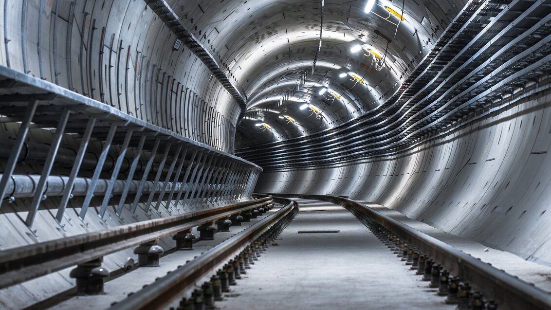 Image of a metro tunnel, rails in the middle of the photograph with the lights reflected in circular shapes