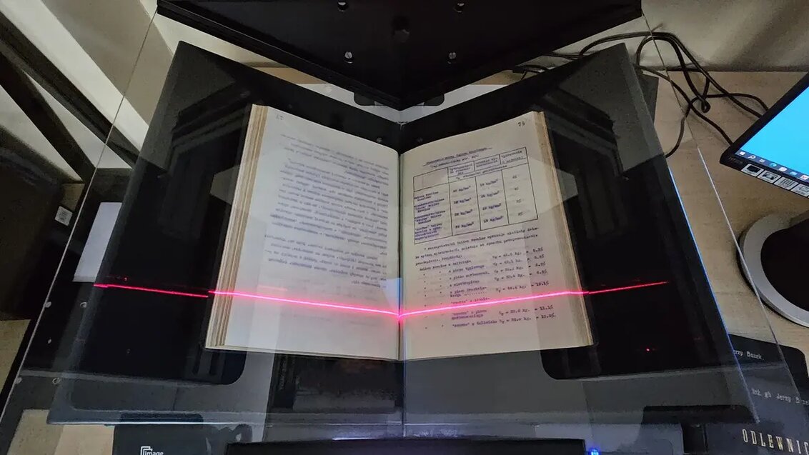 Image of the process of digitisation of a book which is placed in a special scanner