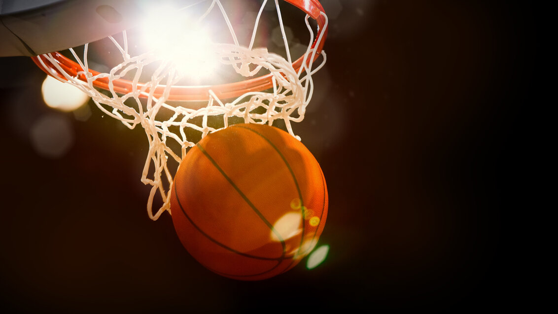 Image of a basketball being thrown into the basket