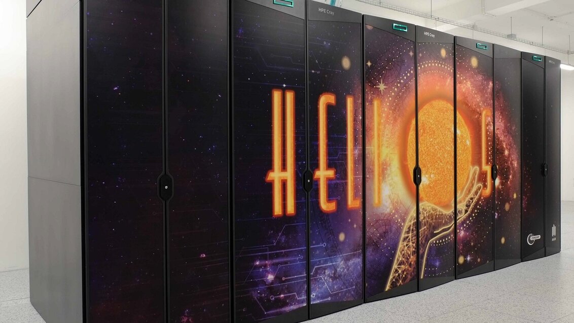 A photo of a supercomputer Helios with its name on the side and an image of a hand holding the Sun