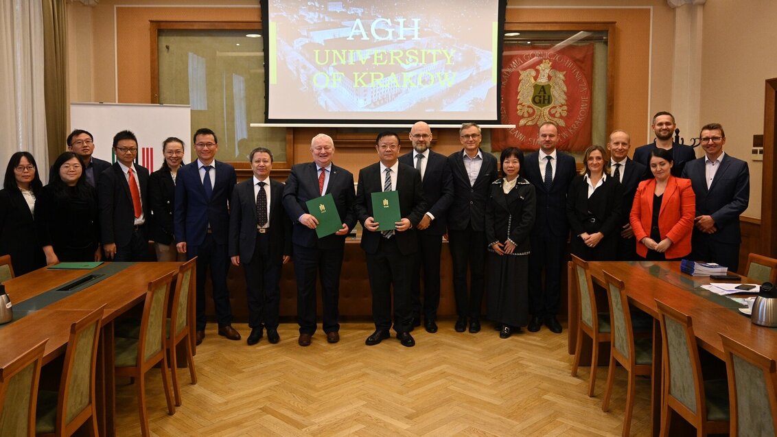 Grupowe zdjęcie uczestników i uczestniczek spotkania wykonane w sali konferencyjnej.