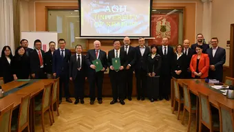 Grupowe zdjęcie uczestników i uczestniczek spotkania wykonane w sali konferencyjnej.