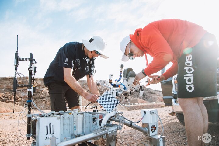 Image of two people working at a Martian rover