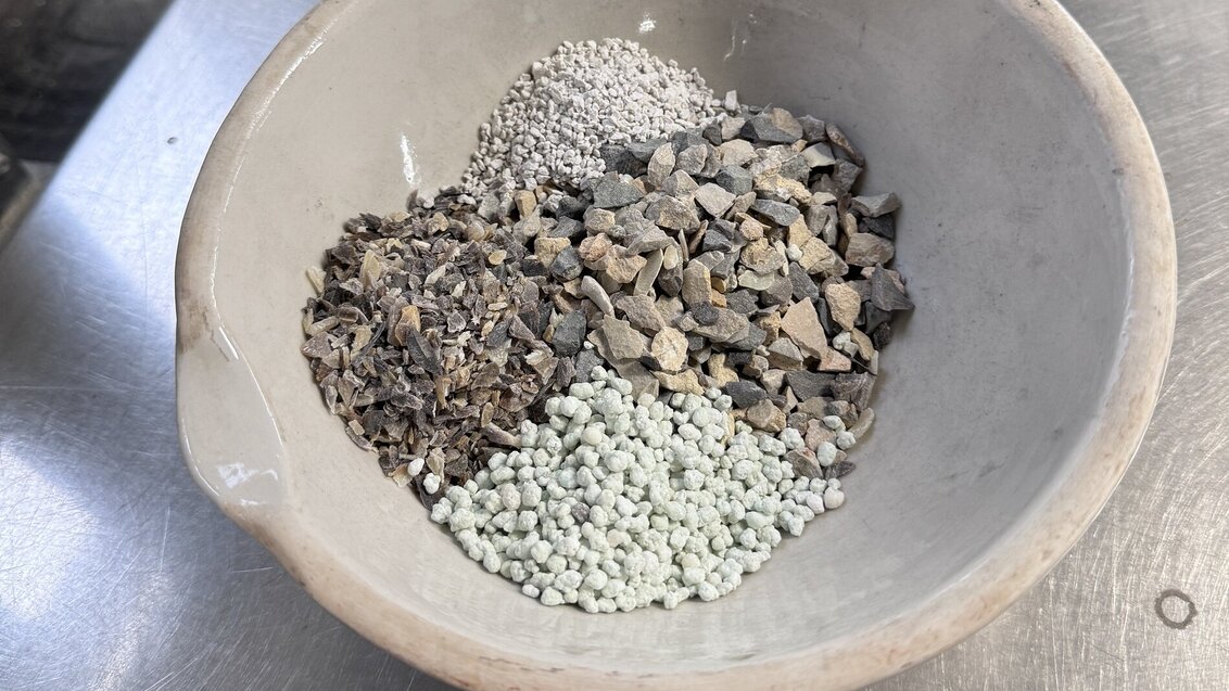 Image of four types of aggregates in a white bowl placed on a metal table