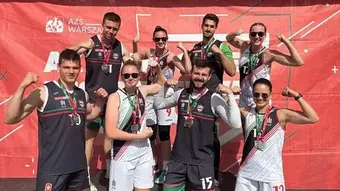 Grupowe zdjęcie koszykarek i koszykarzy z medalami.